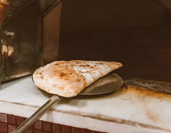 Commander une pizza calzone au feu de bois avec une bière, Nice, Le Don Carlo